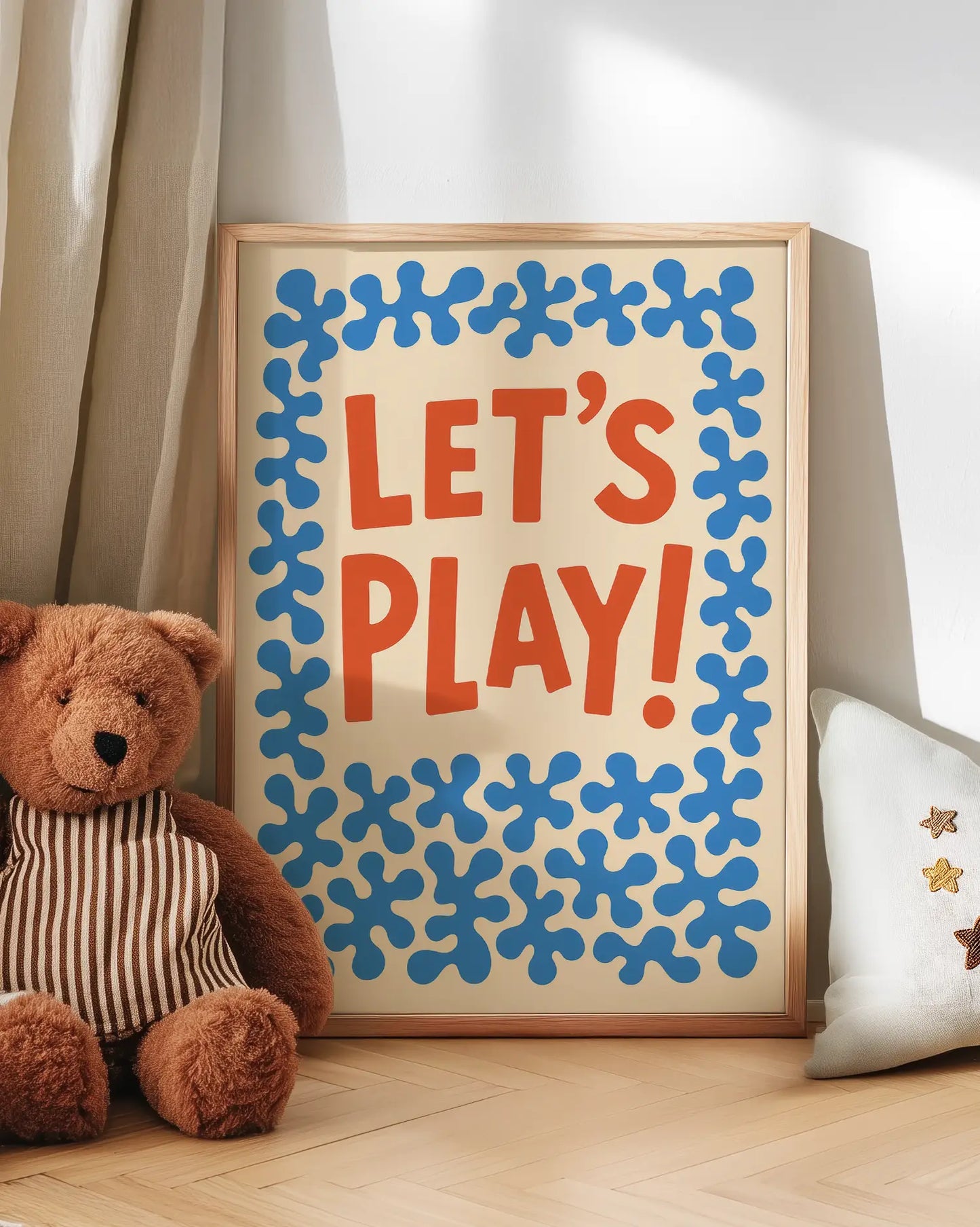 Poster with 'LET'S PLAY!' text and teddy bear on a wooden floor.