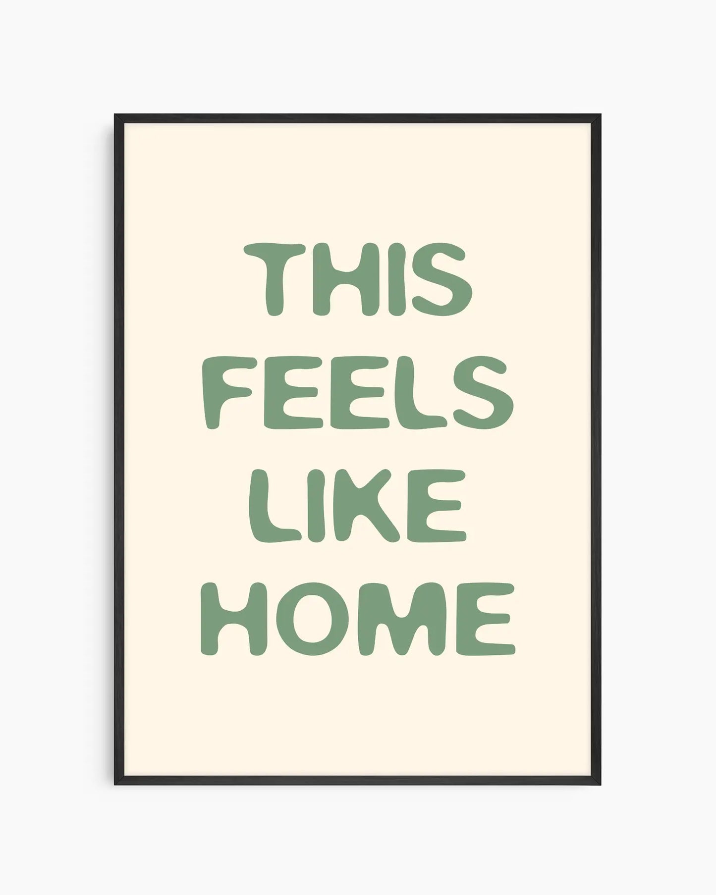 Nursery poster with the text 'This feels like home' written in green, inserted in an black frame