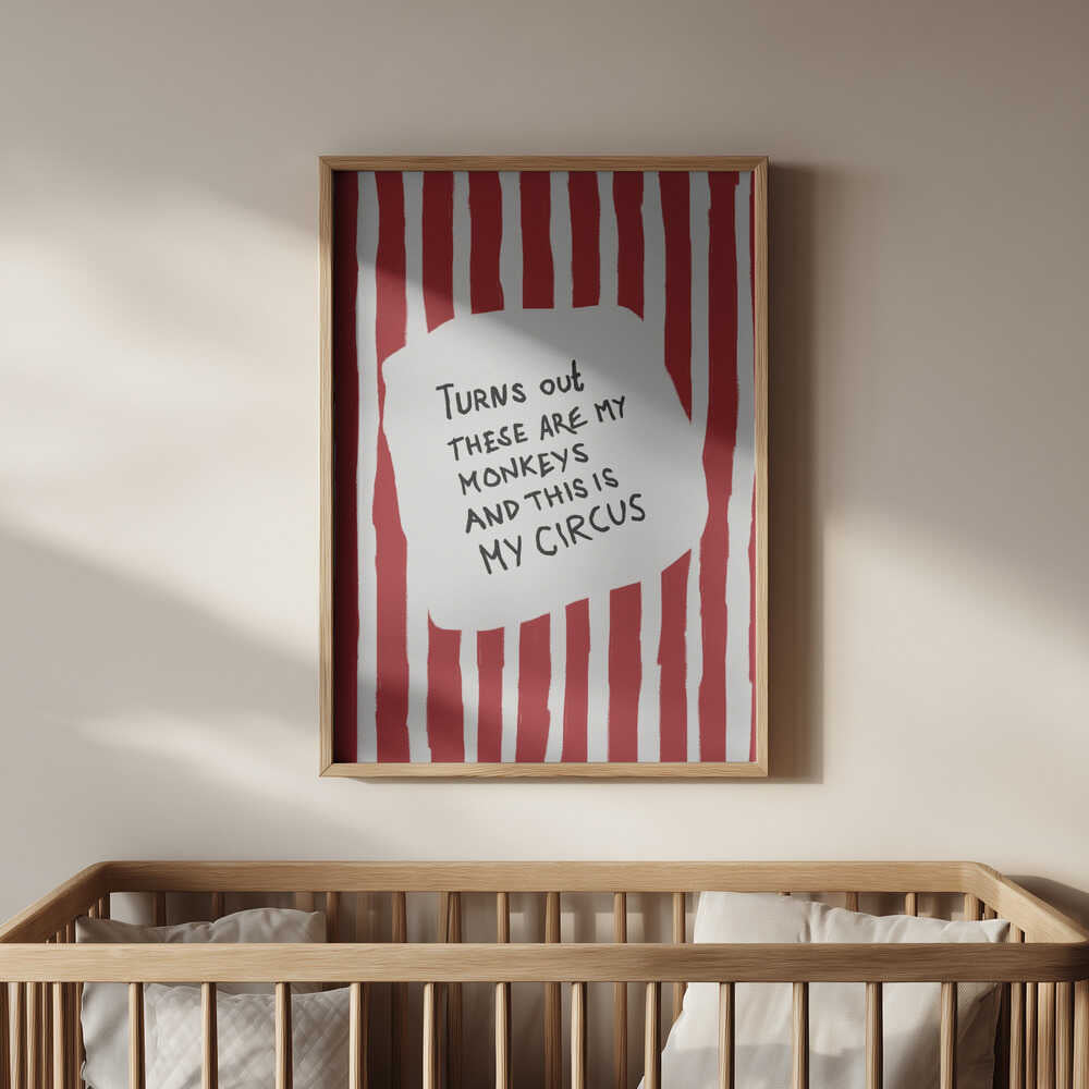 Nursery poster with the text 'Turns out these are my monkeys and this is my circus' on a red and white striped background hanging on the wall above the  baby crib.