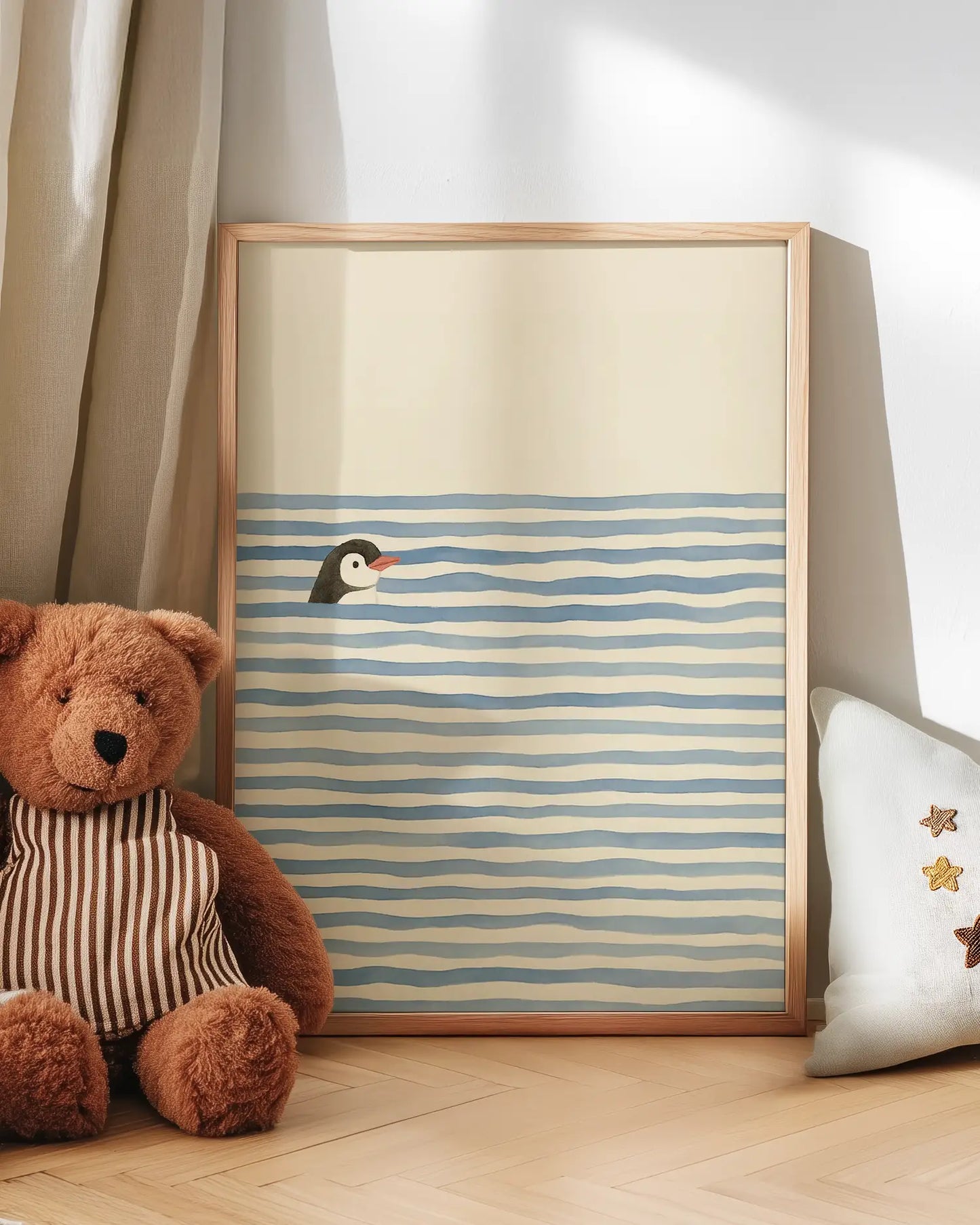 Children's artwork with a penguin design on a striped background, next to a teddy bear and a pillow.
