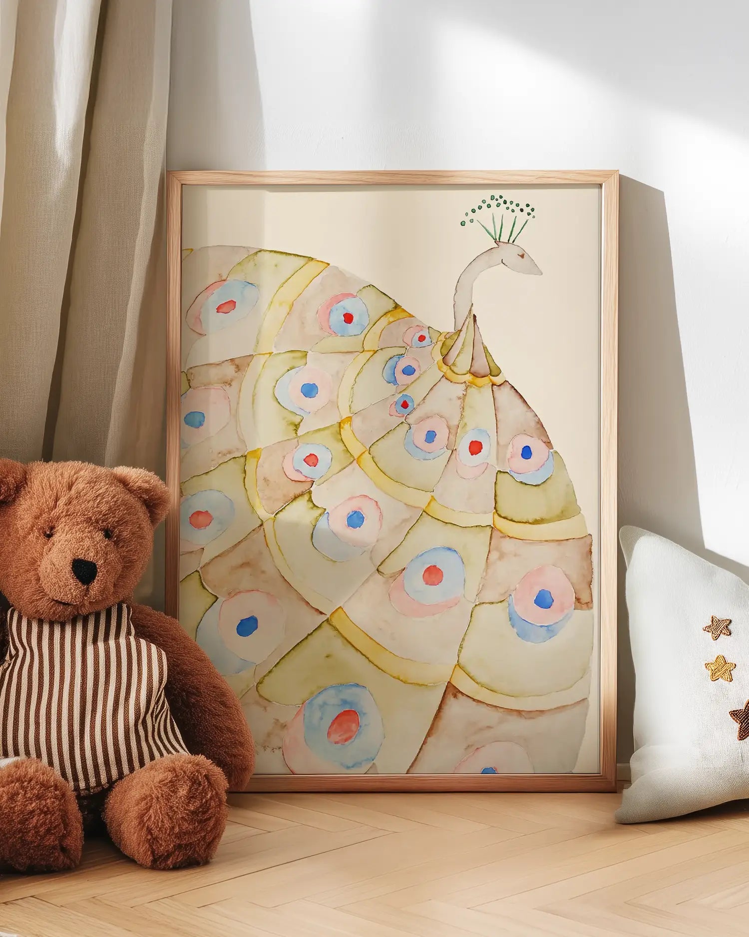 Peacock feather art on a wall with a teddy bear and decorative pillow.