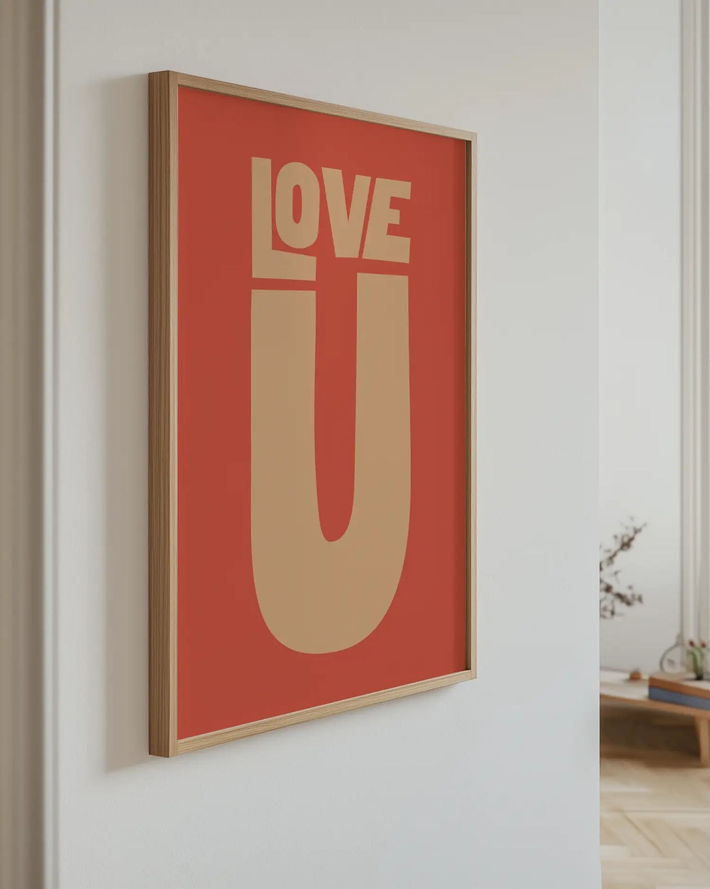 Framed artwork with 'LOVE U' on a red background in a room setting.