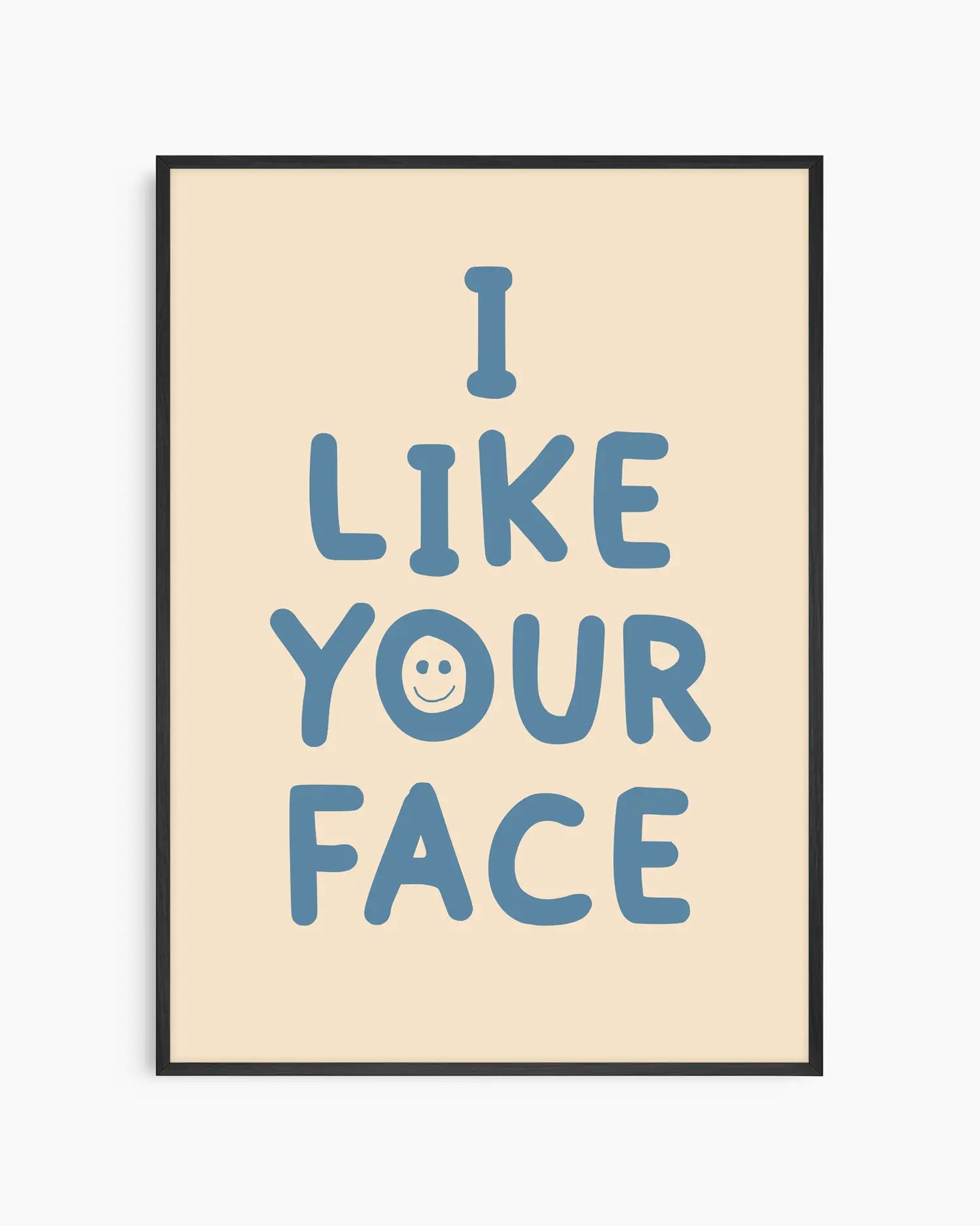 Beige nursery poster with the text 'I like your face' written in blue, framed in a black frame.