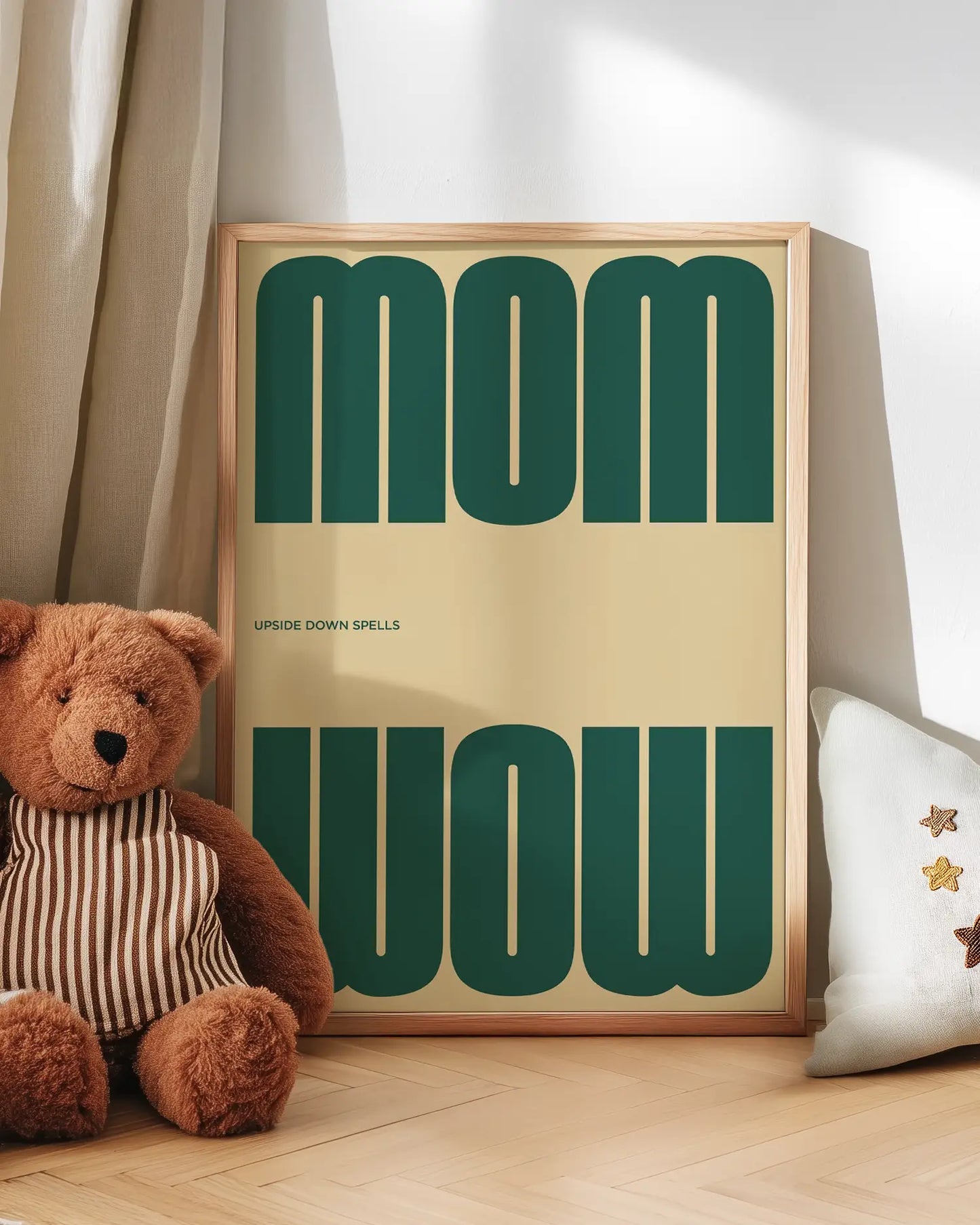 Artwork with 'MOM upside down spells WOW' in green text next to a teddy bear on a wooden floor.
