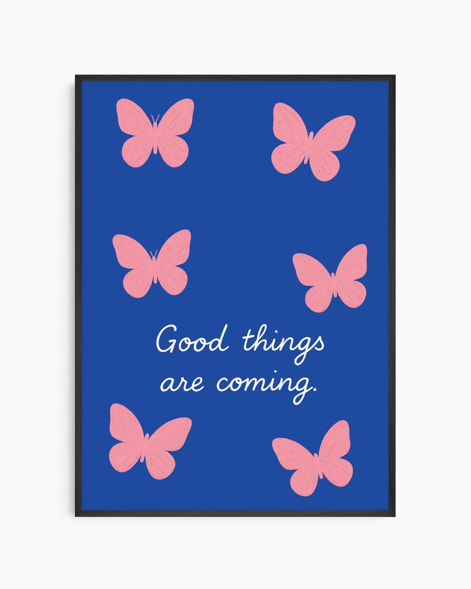 Framed artwork with pink butterflies and 'Good things are coming' text on a blue background
