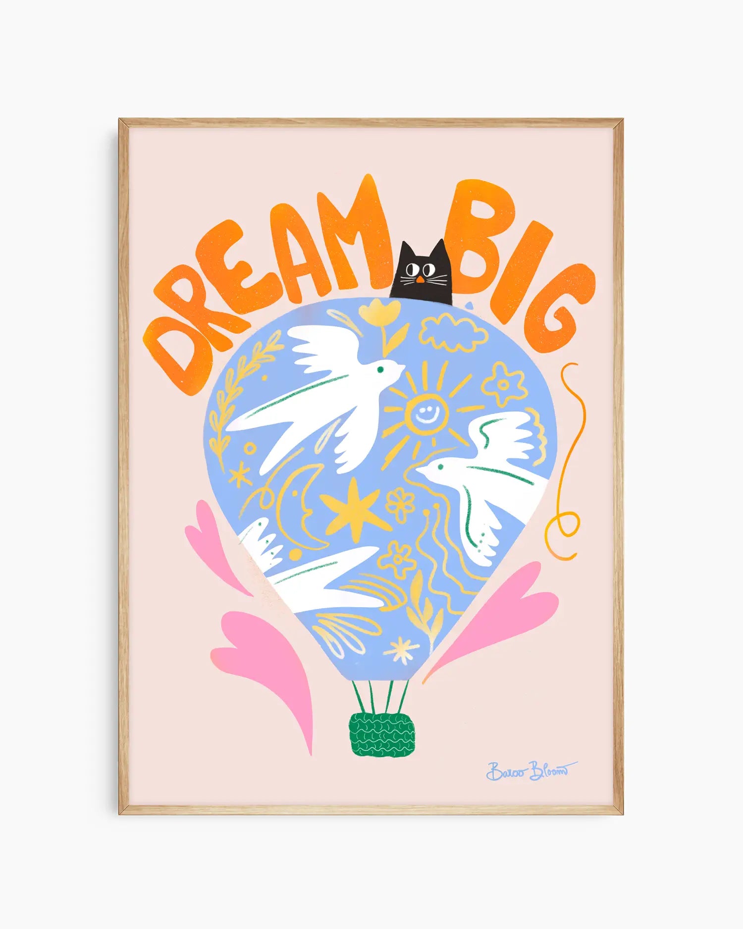 Nursery artwork with a colorful illustration of a hot air balloon, birds, and text "Dream big" on a light pink background. Framed in an oak wooden frame.