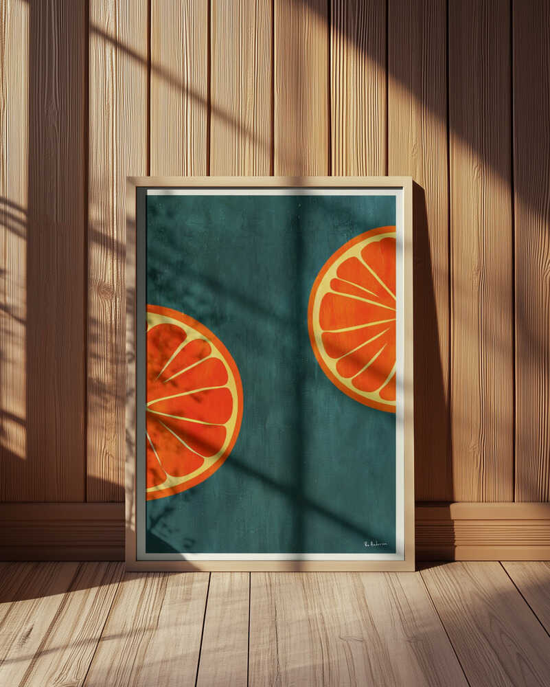 Vibrant orange art print featuring two stylized citrus slices on a deep teal background. Displayed in a light wooden frame leaning against a wooden wall, with soft sunlight and shadows. Modern kitchen wall art with a bold, retro-inspired design.