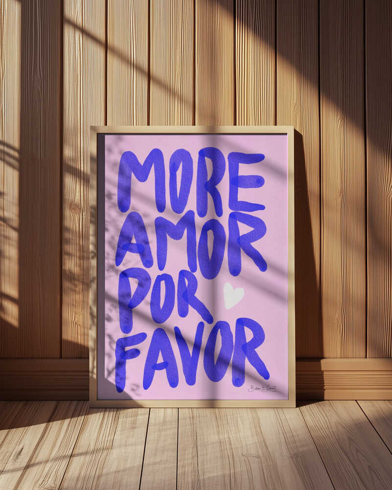 Framed nursery poster with purple text 'MORE AMOR POR FAVOR' leaning against a wooden wall.