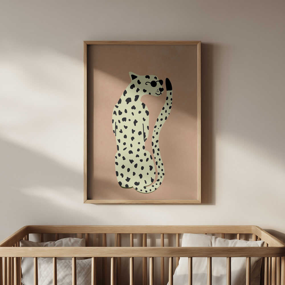 Stylish leopard poster with beige background and black spots, framed in light wood and hanging on a white wall above a baby’s crib. A calm, modern detail that complements a soft and neutral nursery decor.