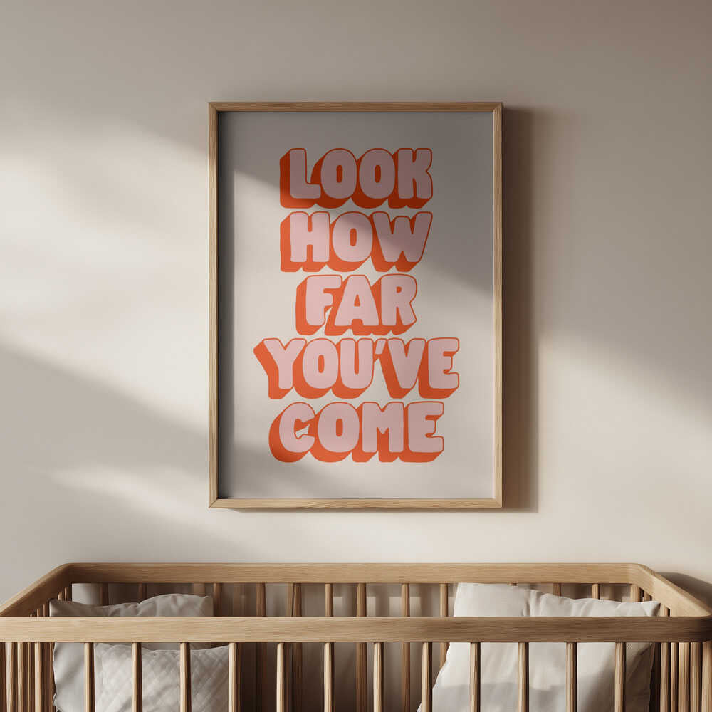 Poster with 'Look how far you've come' pink and red text on a light background hanging above the baby crib